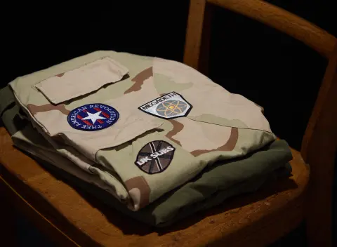 "An Abridged Sonic History of Global Conflict" - installation detail, Judith and Norman Alix Art Gallery - Embroidery on army surplus, wooden chair and stage